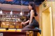 A woman sitting on top of a pool table.