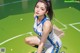 A woman kneeling on a basketball court wearing a blue and white uniform.