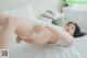 A woman laying on top of a white bed.