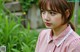 A young woman wearing a pink shirt and red lipstick.