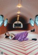 A woman laying on the floor in a room with round windows.