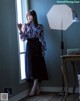 A woman standing in front of a window in a room.