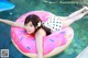 A woman laying on an inflatable donut floating in a pool.